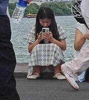 街拍美女穿着裙子坐在路边走光露出裙底可爱内裤2